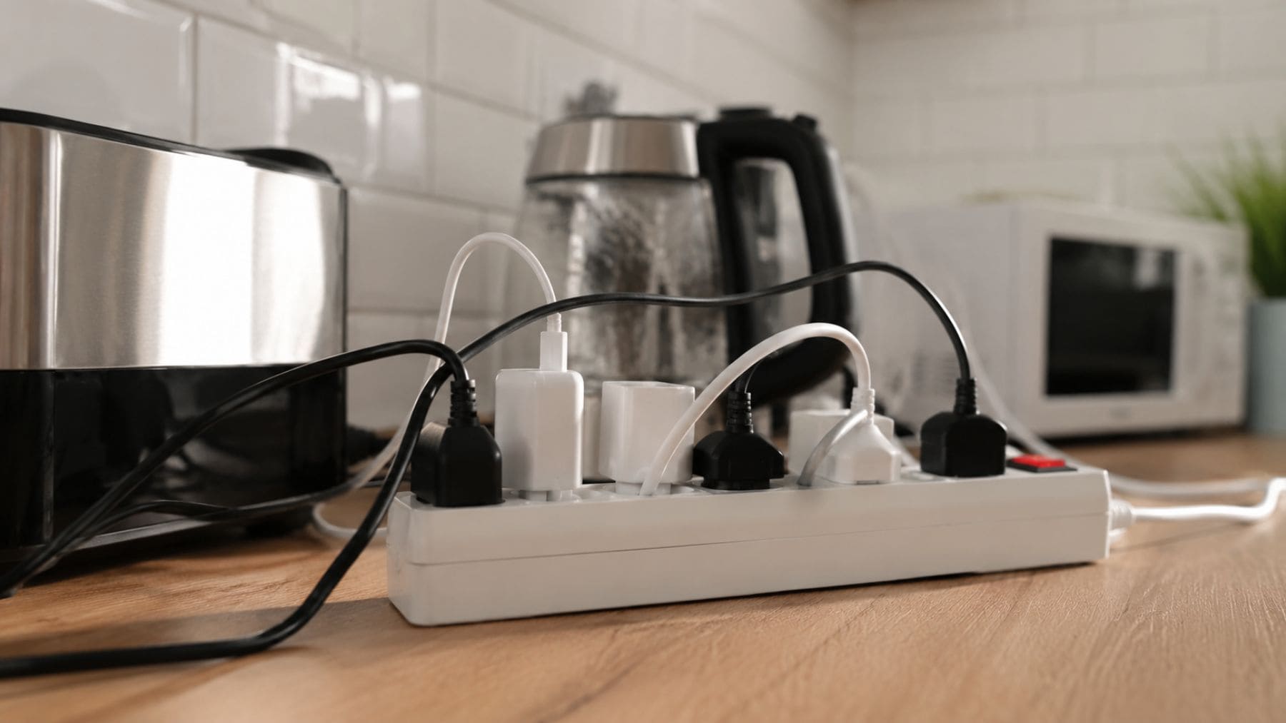 Regleta sobrecargada con varios electrodomésticos conectados en una cocina doméstica