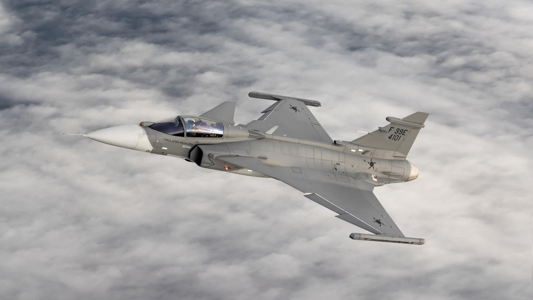Avión de combate supersónico F-39E Gripen de la Fuerza Aérea Brasileña durante un vuelo de pruebas sobre las nubes.