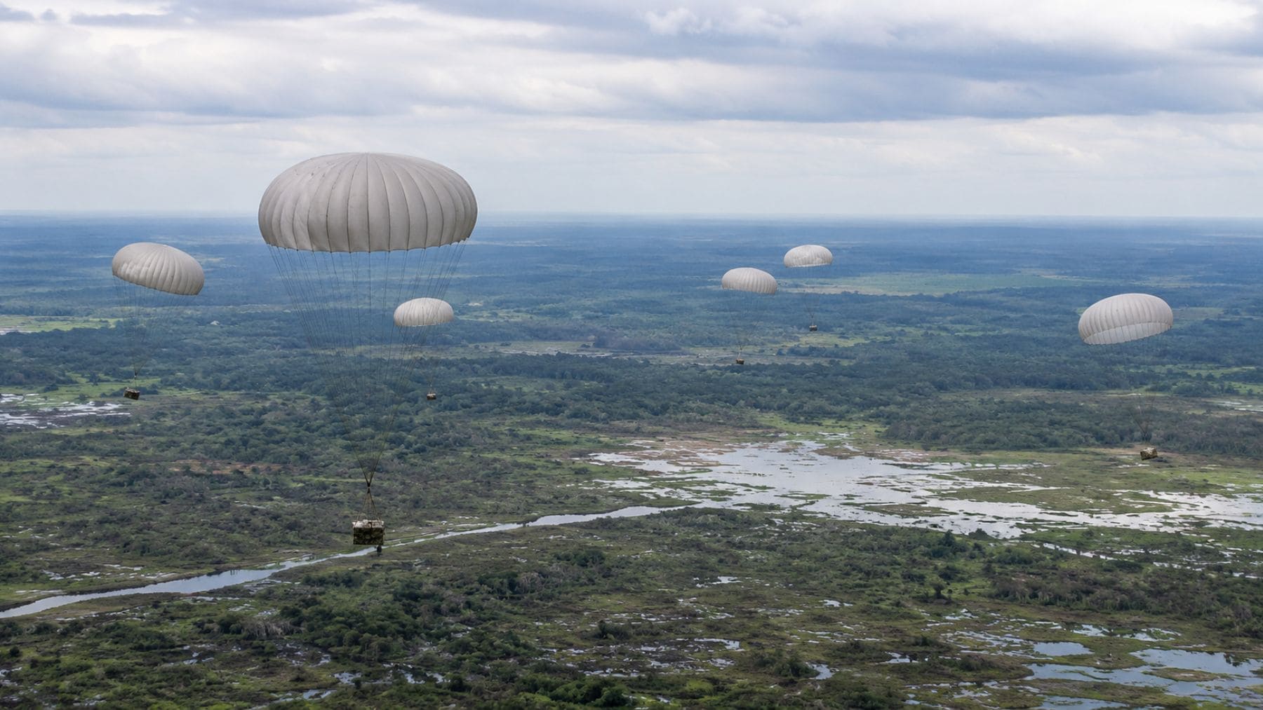 Paracaídas lanzan más de 1,5 toneladas de suministros del Ejército de Colombia sobre Casanare durante una operación de abastecimiento aéreo