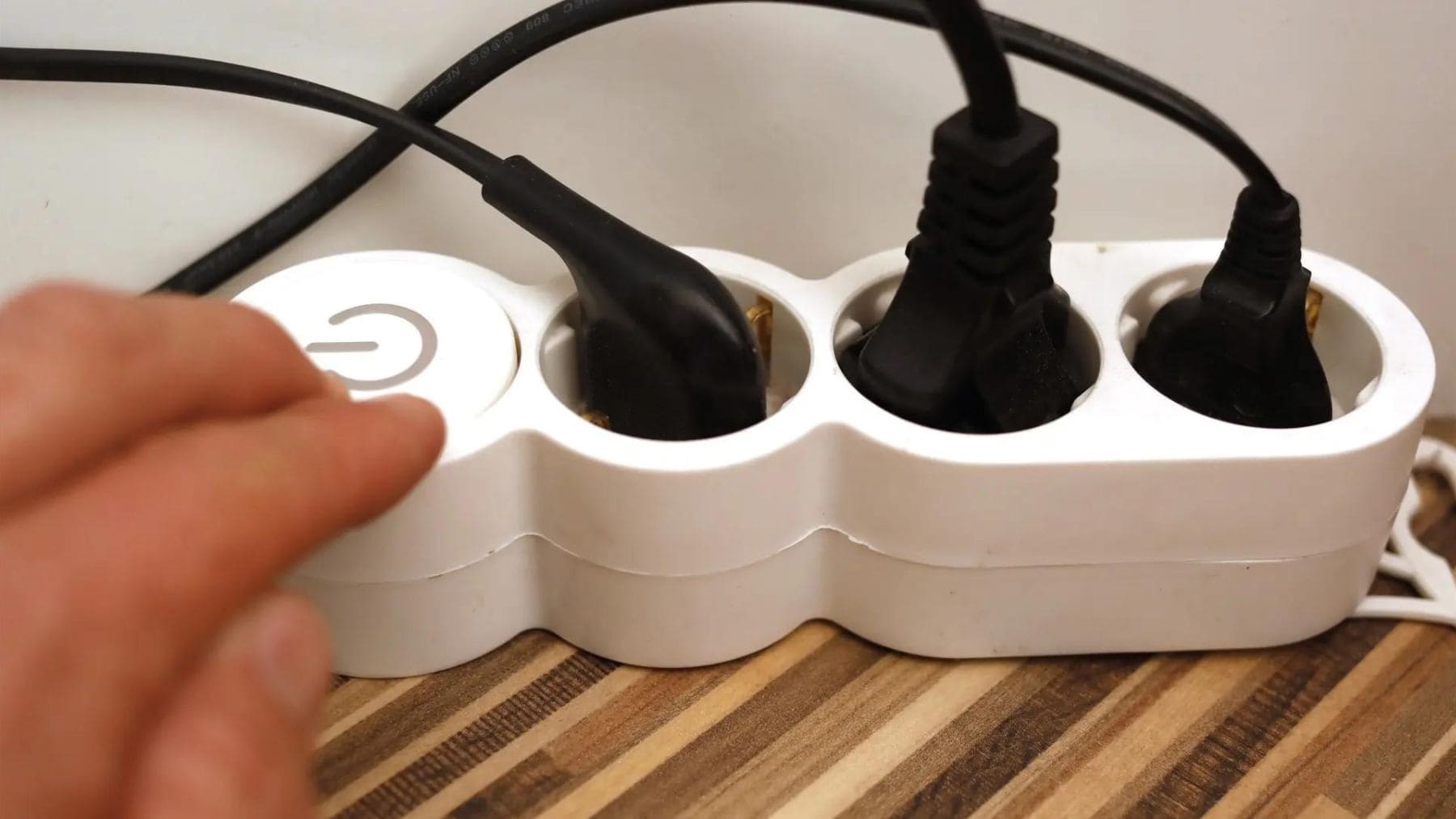 Regleta eléctrica conectada con varios enchufes en una vivienda, un elemento que debe mantenerse lejos de ventanas y humedad.