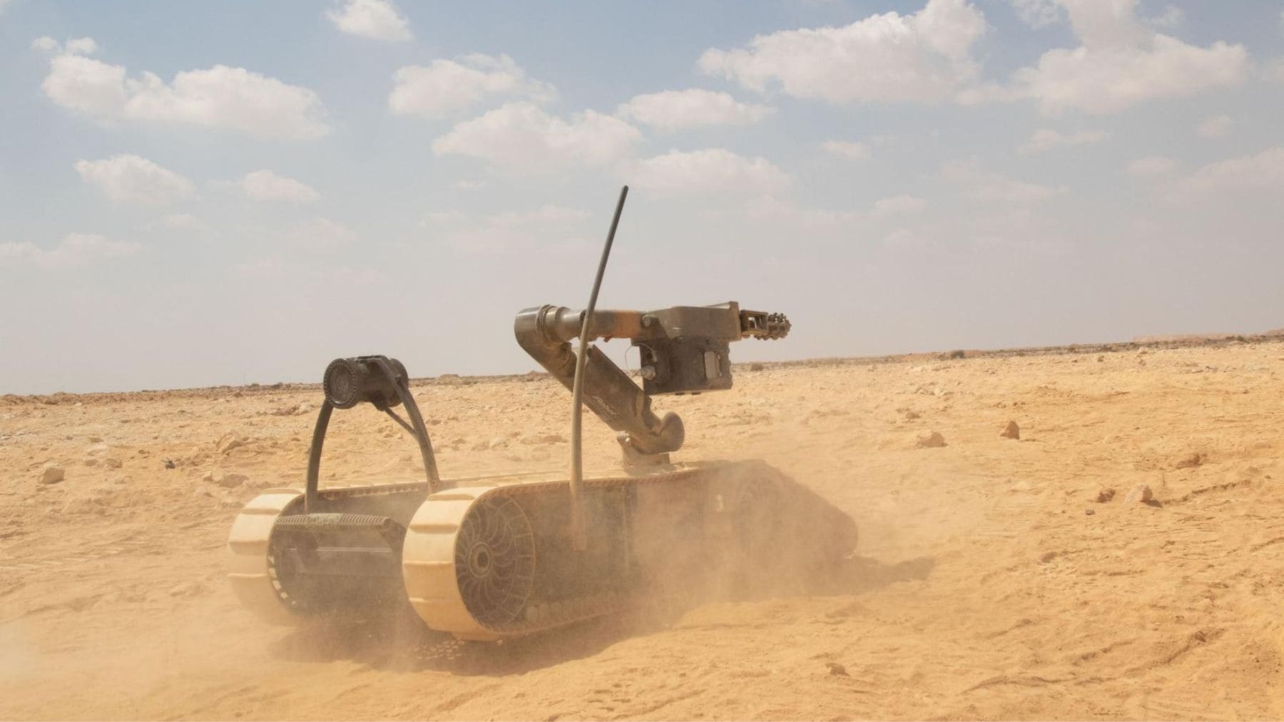 Robot militar autónomo equipado con sensores e inteligencia artificial durante una operación en terreno desértico.