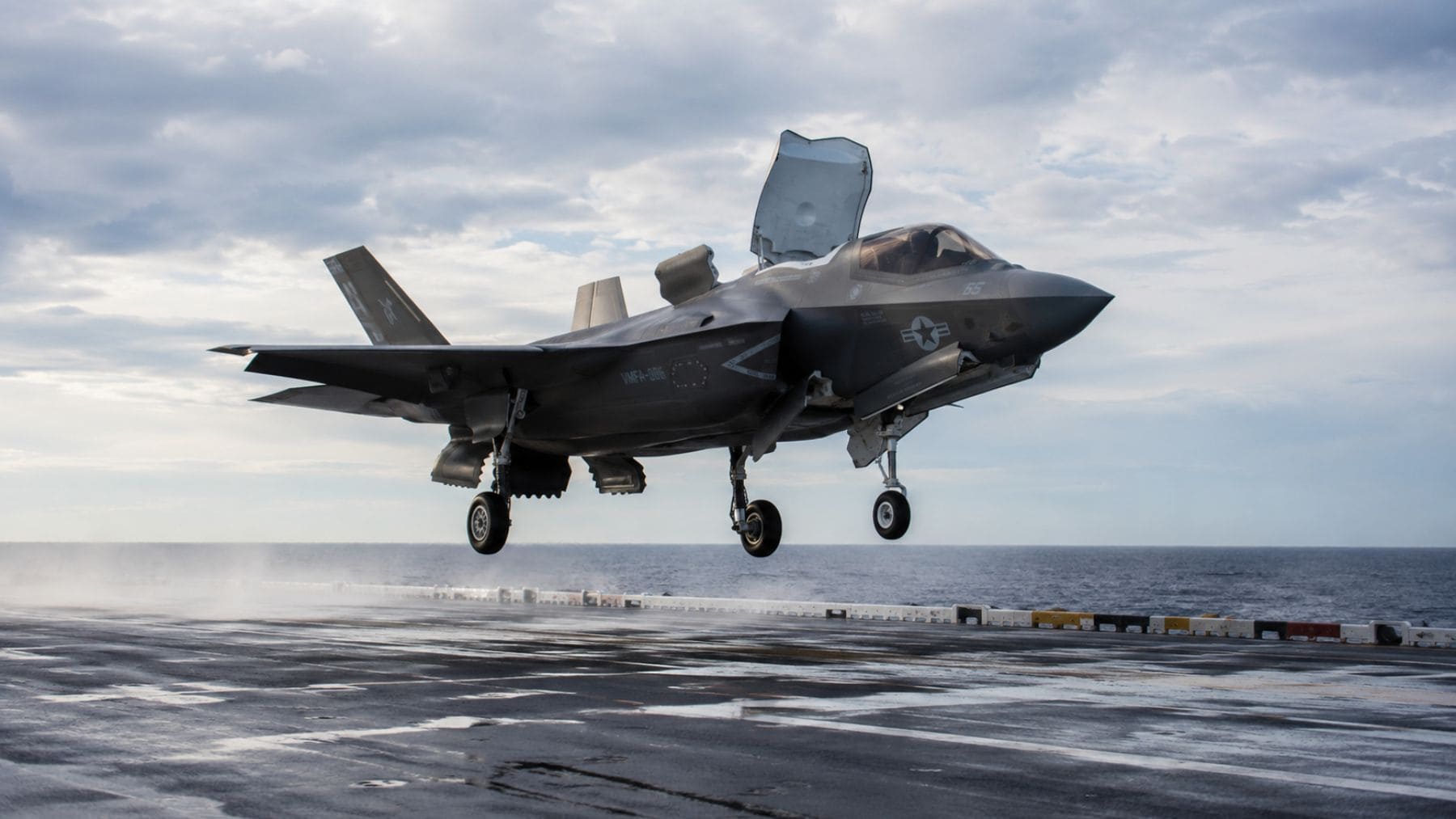 Caza de combate F-35B realizando una maniobra de aterrizaje vertical sobre la cubierta de un portaaeronaves.