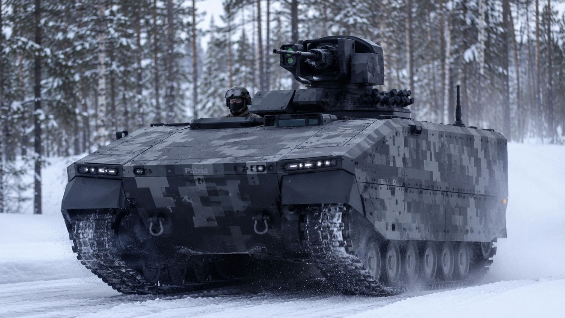 Blindado de orugas Patria TRACKX circulando sobre nieve durante unas pruebas en un bosque de Finlandia.