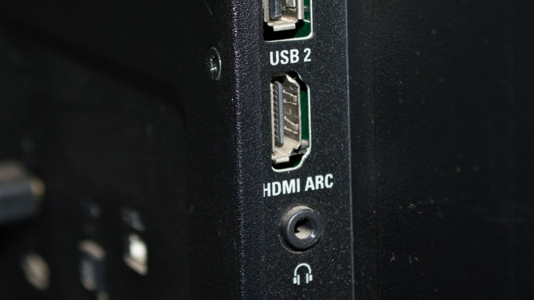 Puerto HDMI ARC en la parte trasera de un televisor junto a las conexiones USB y salida de auriculares.