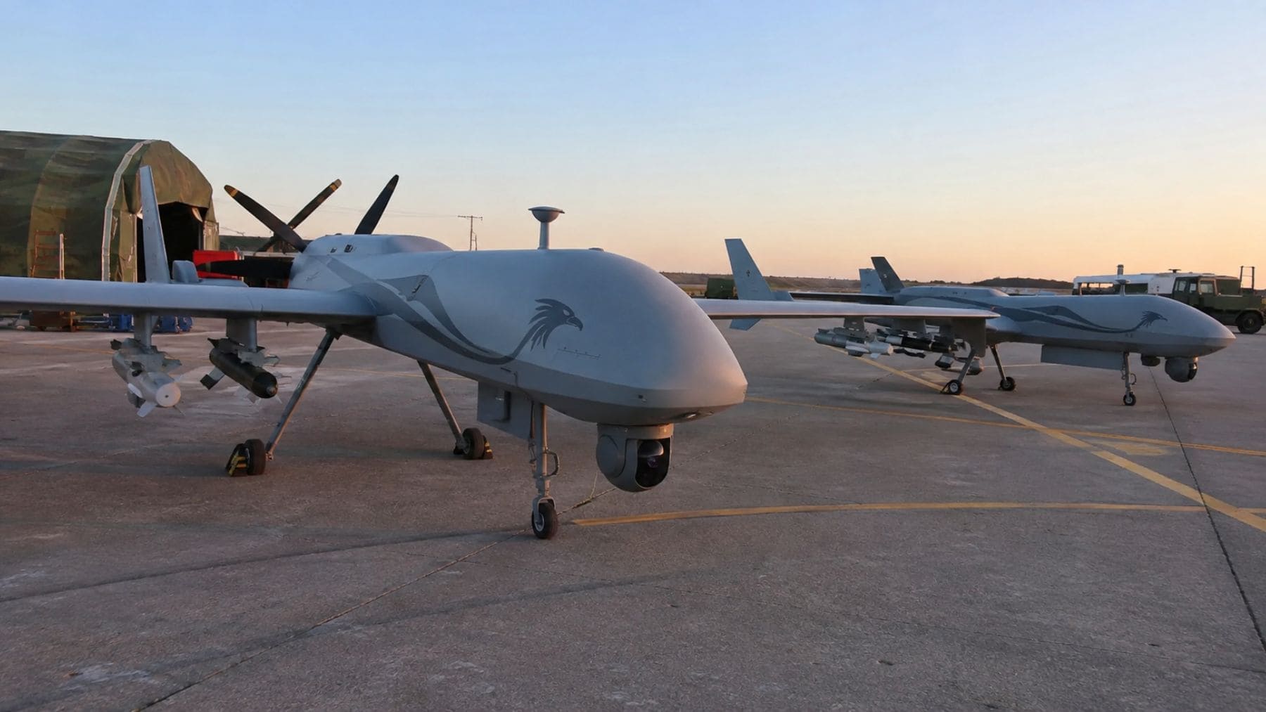 Drones militares de combate en una base aérea que representan la cooperación en defensa entre China y Serbia